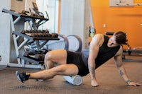 a man in a gym doing an exercise on a foam roller